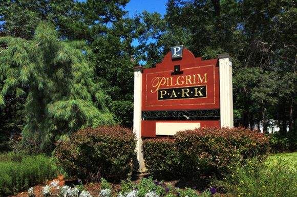 a sign for a park with trees in the background