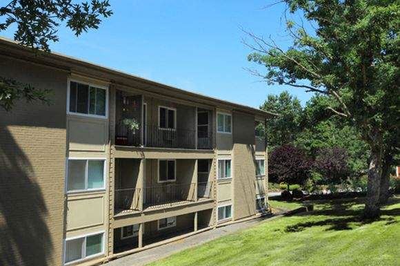 a large apartment building with a grassy yard