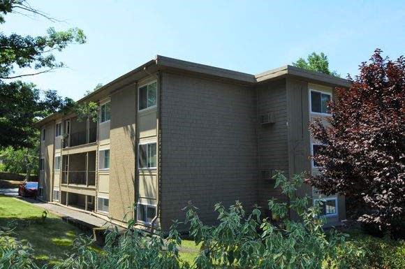 an apartment building with a tree in front of it