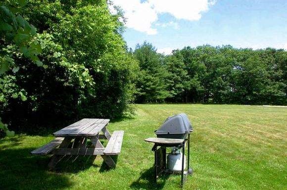 two picnic tables sitting in a grass field
