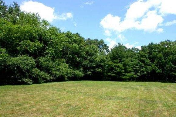 a large field of grass and trees in a field