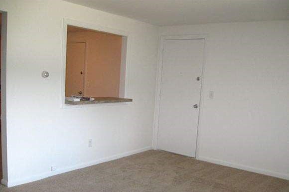 an empty living room with a window and a door
