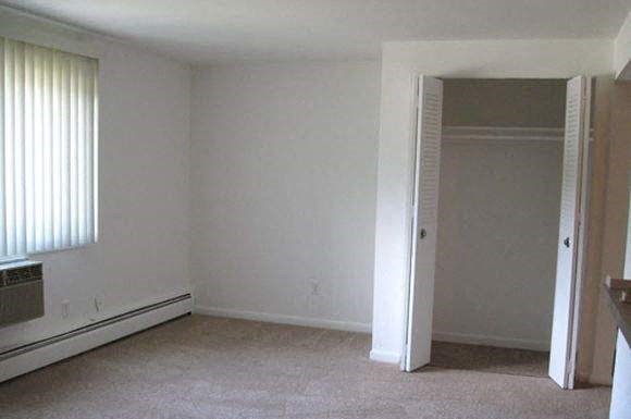 an empty living room with a door to a closet