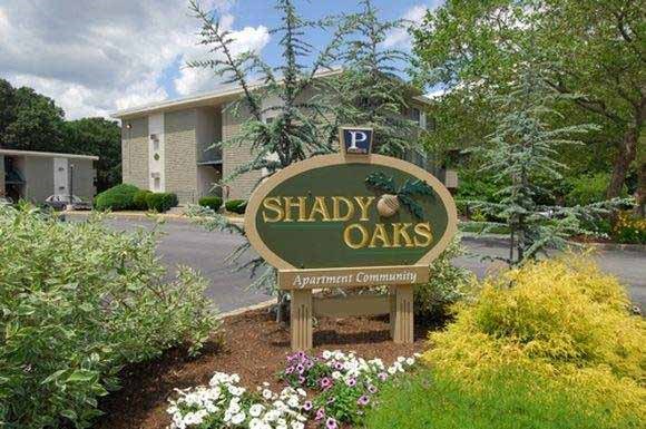 a sign for shady oaks in front of a building