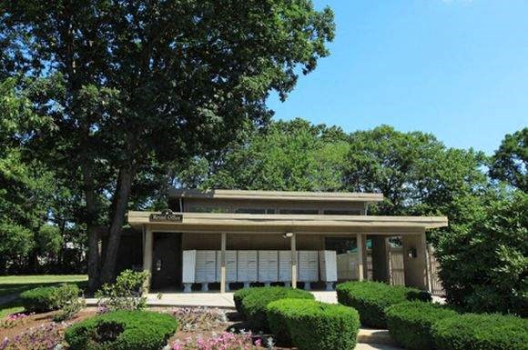 a house with a porch and a tree in front of it
