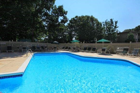 a large blue swimming pool with chairs around it