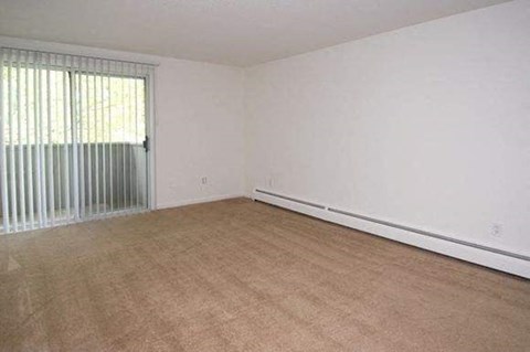 an empty living room with white walls and a large window