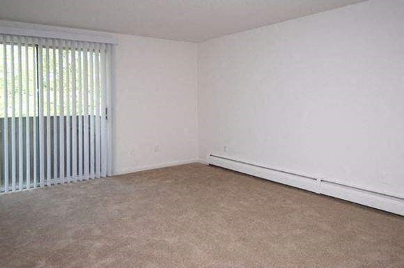 an empty room with a large window and white walls