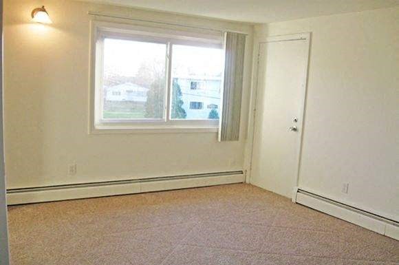 an empty room with a window and a door