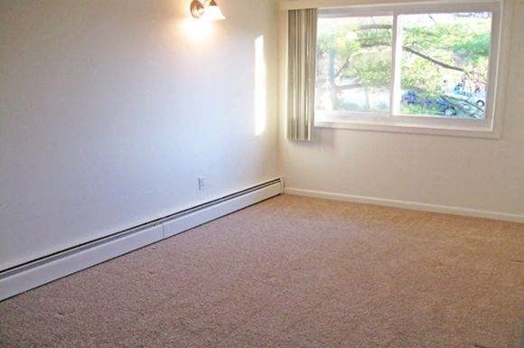 an empty room with a window and white walls