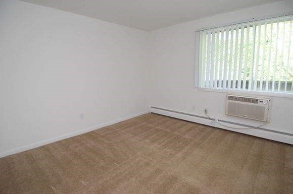 an empty room with a heater and a window