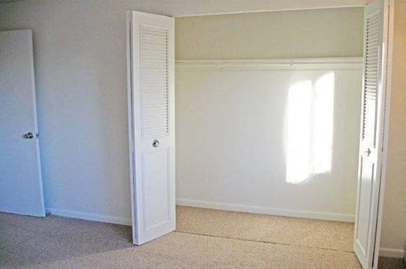 an empty room with a closet and a door