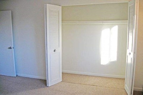 an empty room with a closet and a door