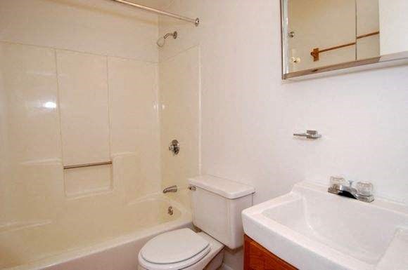 a white bathroom with a toilet and a sink