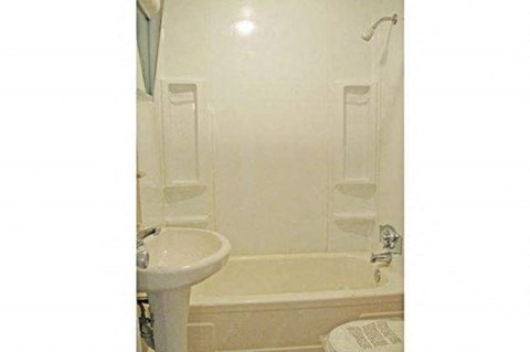 a white bathroom with a sink and a bath tub