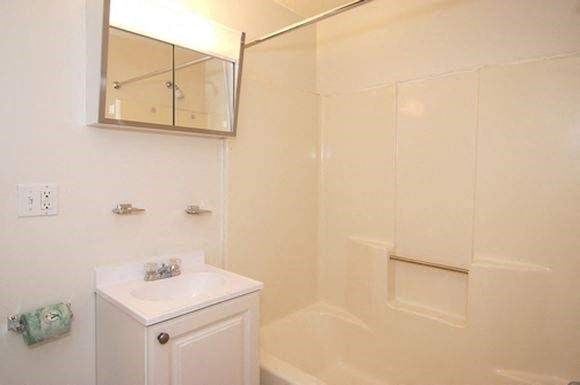 a white bathroom with a sink and a shower