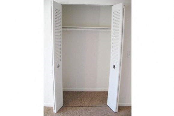 an empty closet with a door open