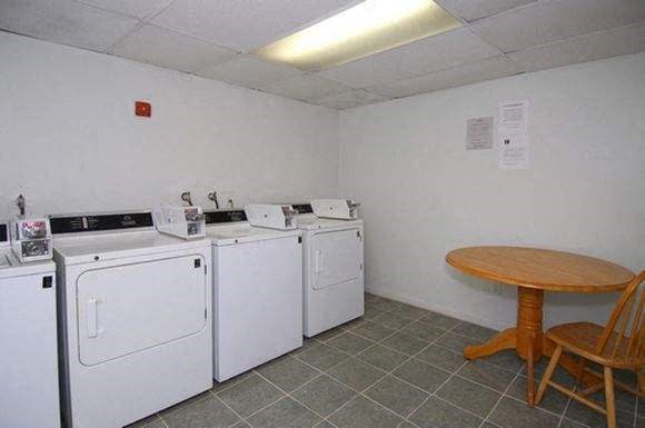 a room with four washing machines and a table