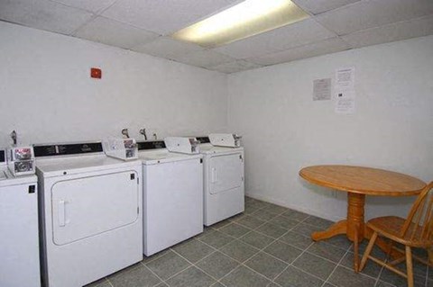 a room with four washing machines and a table
