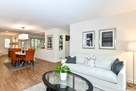 a living room with a white couch and a glass table