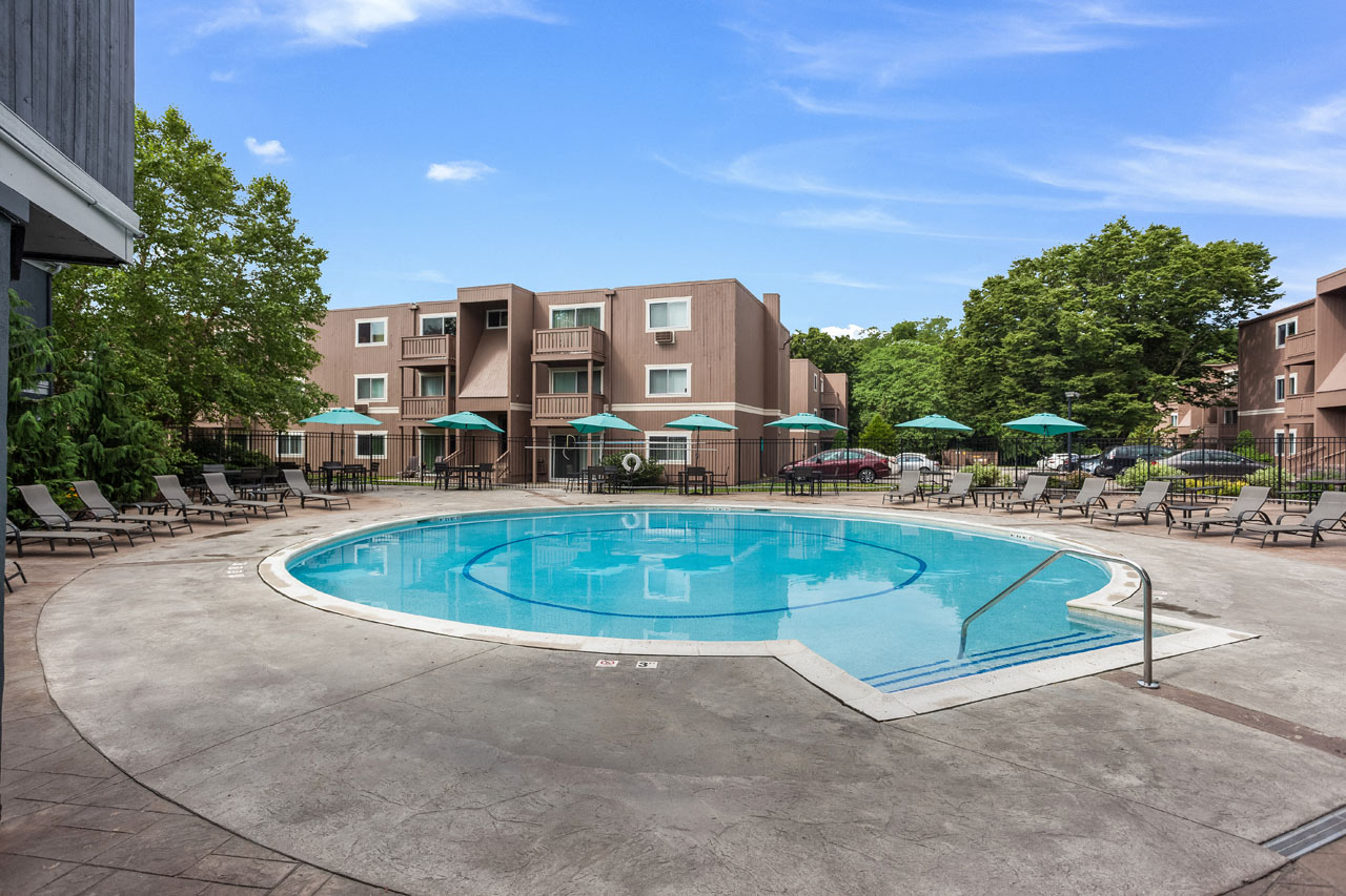 our apartments have a resort style pool with chairs and umbrellas
