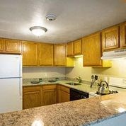 a kitchen with a white refrigerator freezer next to a stove top oven