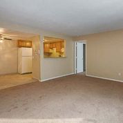 an empty living room and a kitchen in a house
