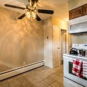 a kitchen with a stove and a ceiling fan