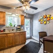 a kitchen with a table and chairs and a ceiling fan
