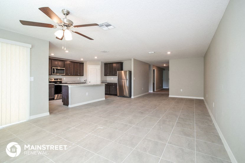 a spacious kitchen with stainless steel appliances and tile flooring