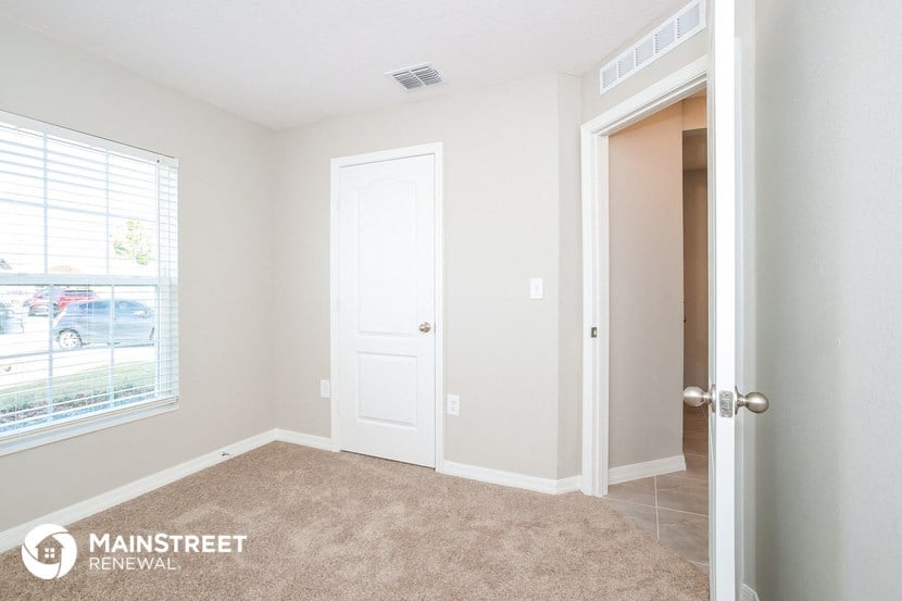 a bedroom with a door to a closet and a window