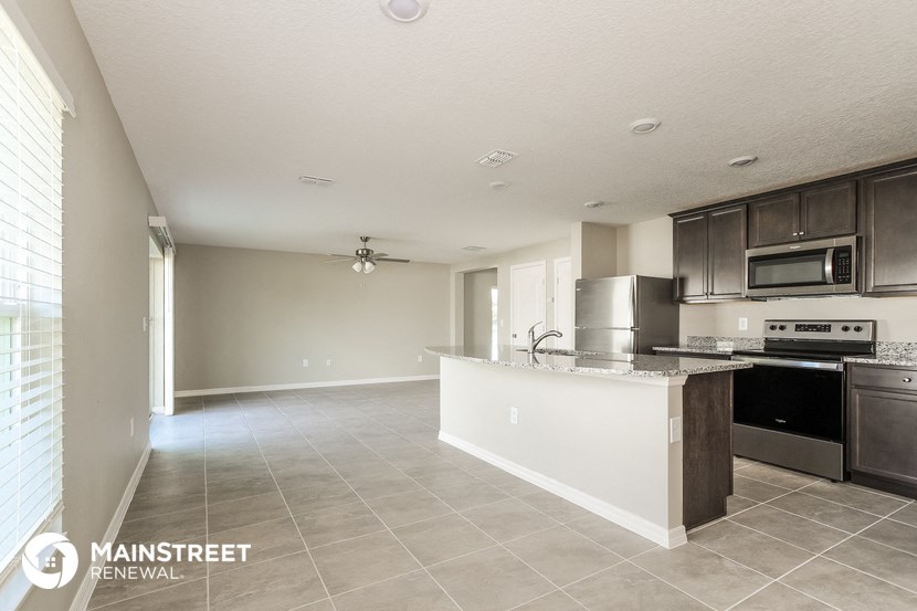 a kitchen with a large island and a stove and a refrigerator