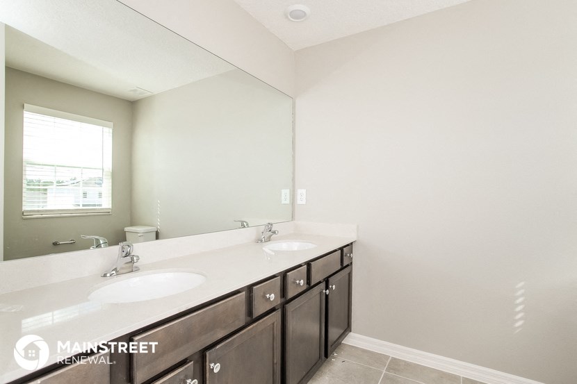 a bathroom with two sinks and a large mirror