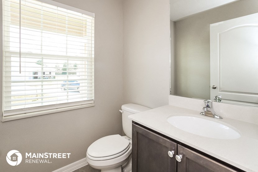 a bathroom with a sink toilet and a window