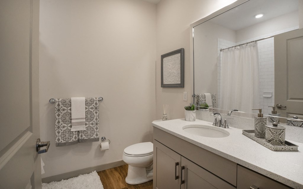 a bathroom with a toilet sink and shower and a mirror
