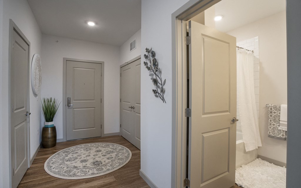 a hallway with a door to a bathroom and a shower