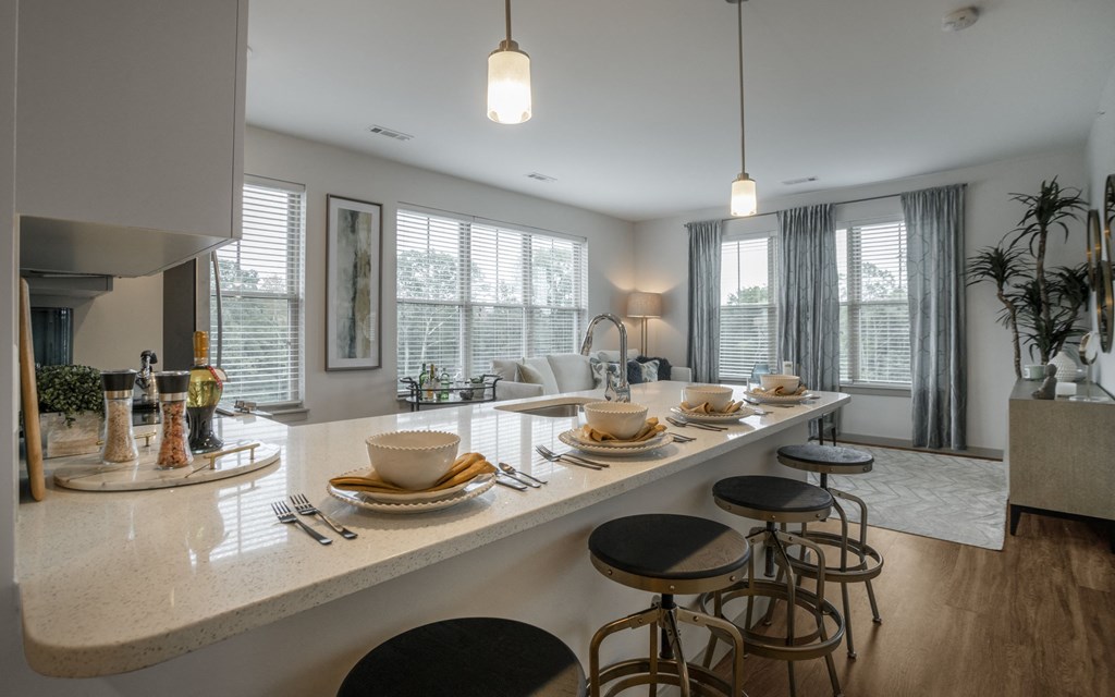 an open kitchen and living room with a bar and stools
