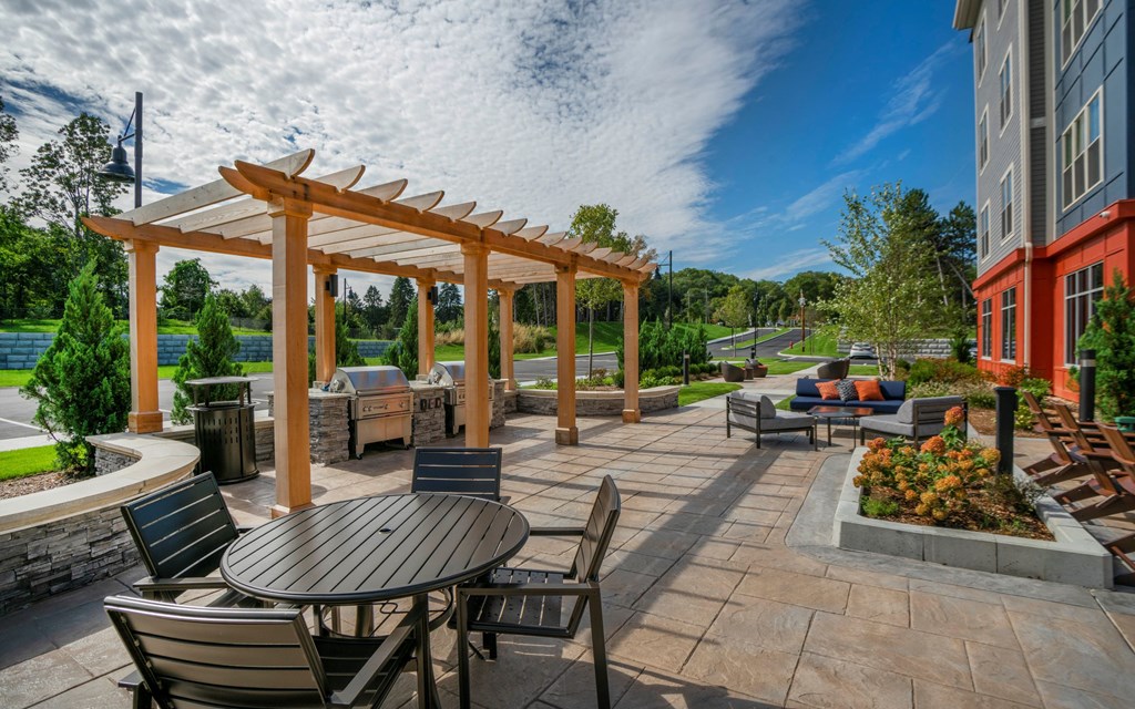 a patio with tables and chairs and a pergola