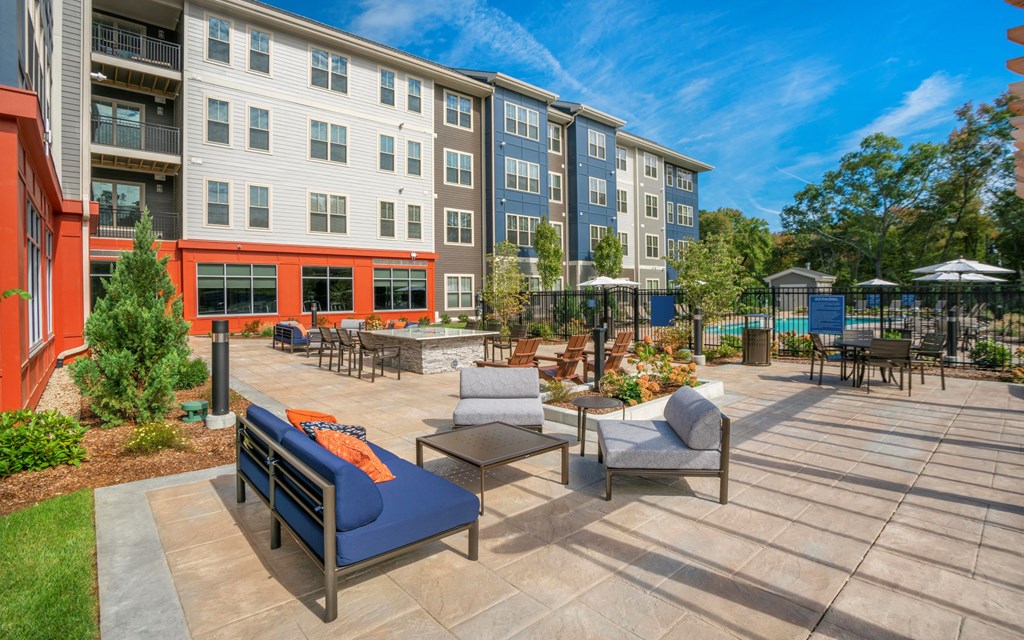 an outdoor patio with chairs and tables and an apartment building