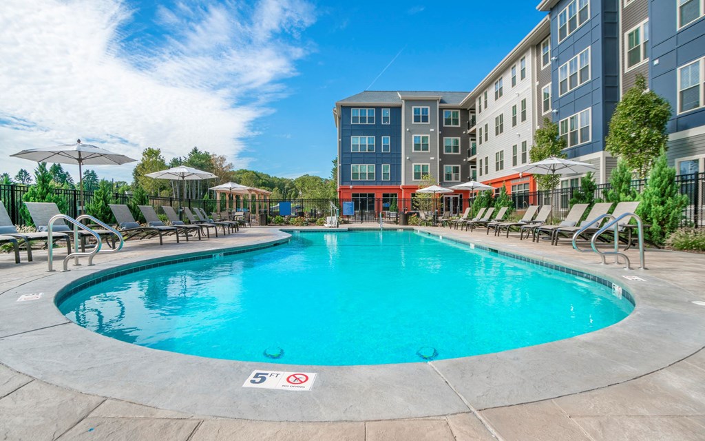 a swimming pool with an apartment building in the background