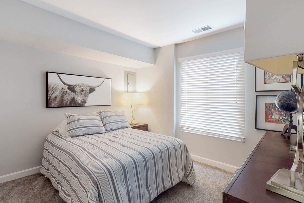 a bedroom with a bed and a painting of a bull