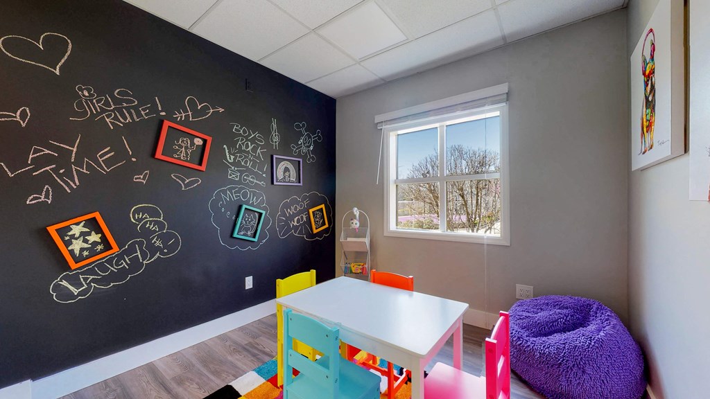 a classroom with a chalkboard wall and a table and chairs