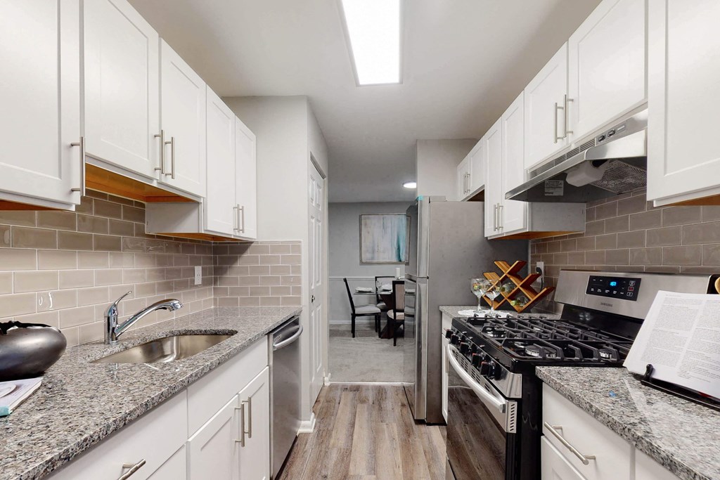 a kitchen with white cabinets and stainless steel appliances