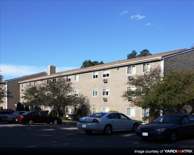 a large brick building with cars parked in a parking lot