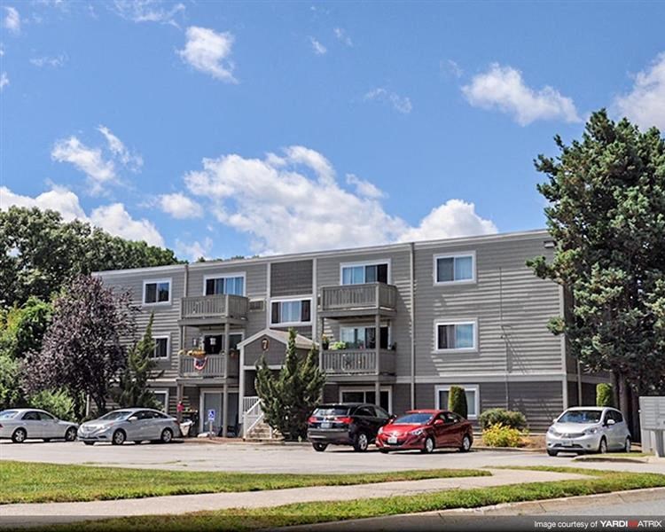 an apartment building with cars parked in front of it