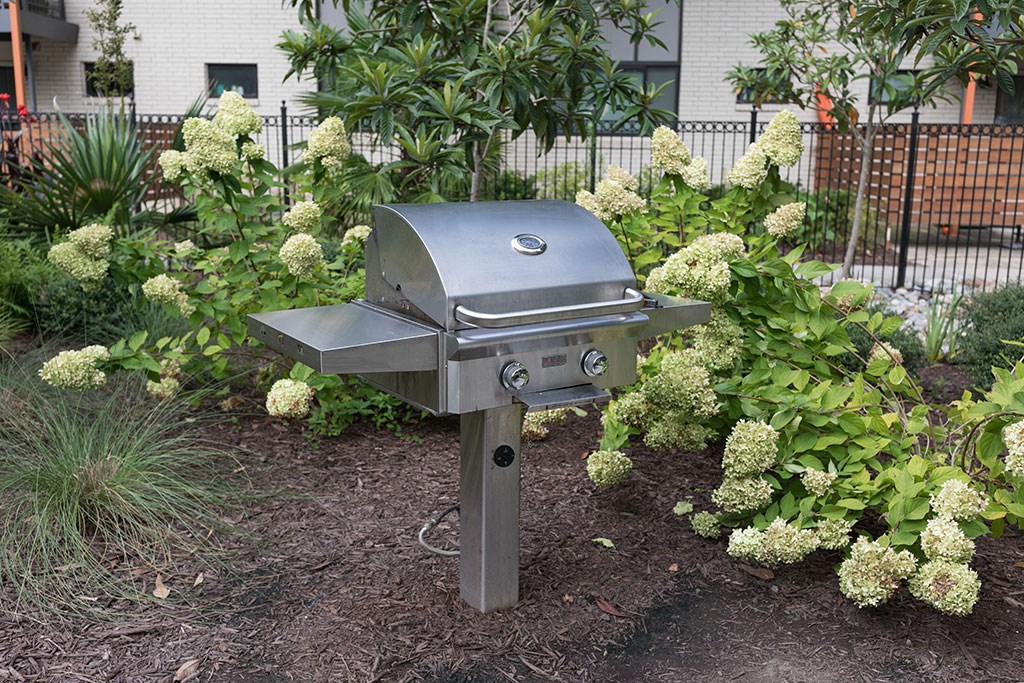 a bbq grill in the middle of a garden