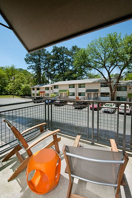 a balcony with two chairs and a orange chair