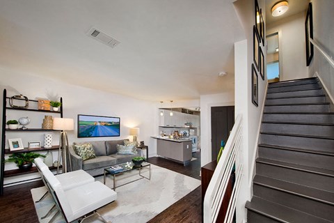 a living room with a couch and a staircase