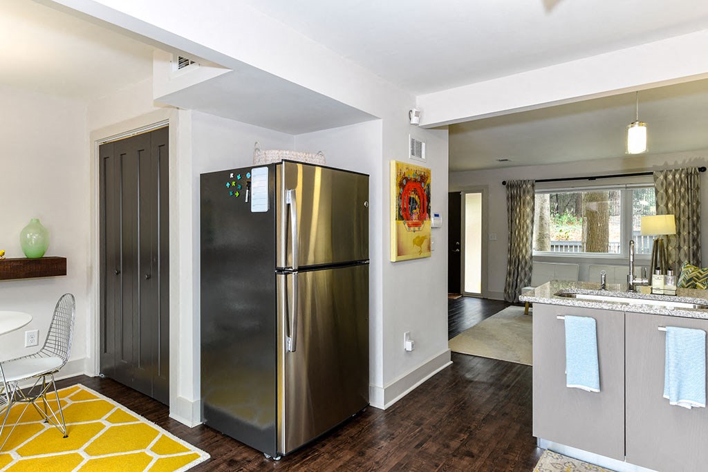 a kitchen and living room with a stainless steel refrigerator