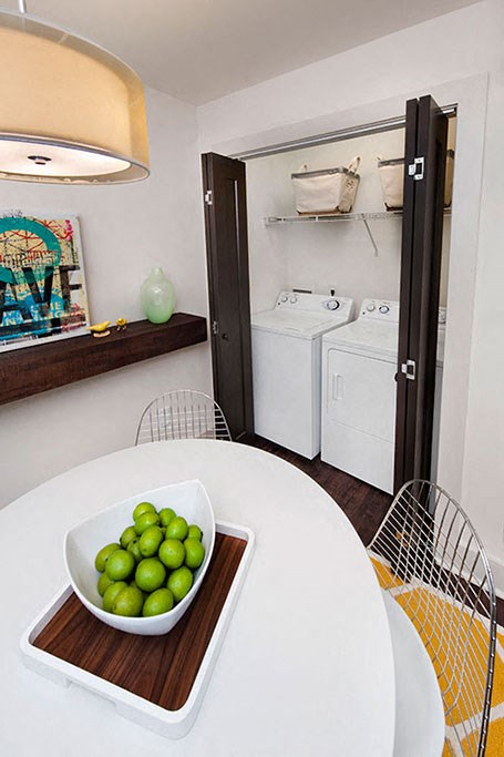 a small kitchen with a white table and a bowl of limes